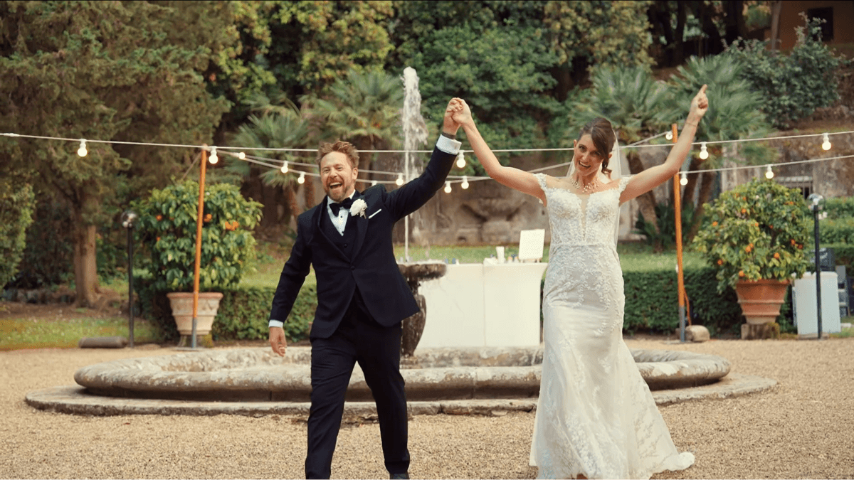 A bride and groom holding hands.